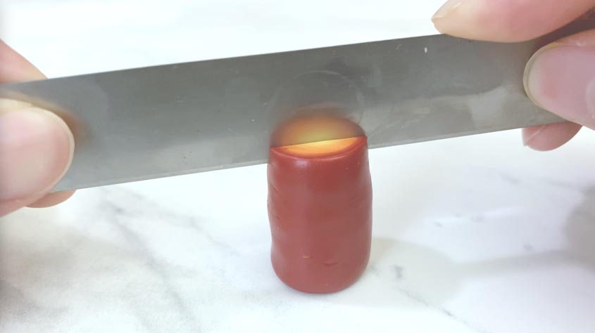 knife slicing into polymer clay bullseye cane
